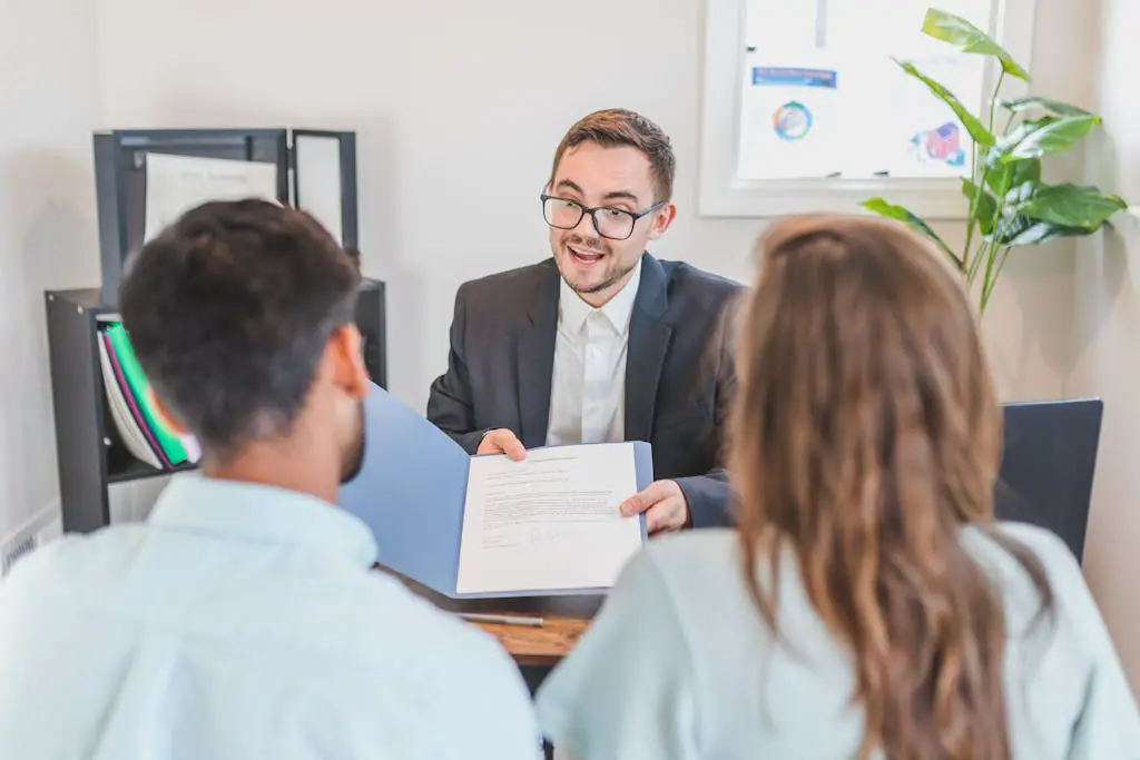 A businessman discusses a contract with clients in a modern office setting.